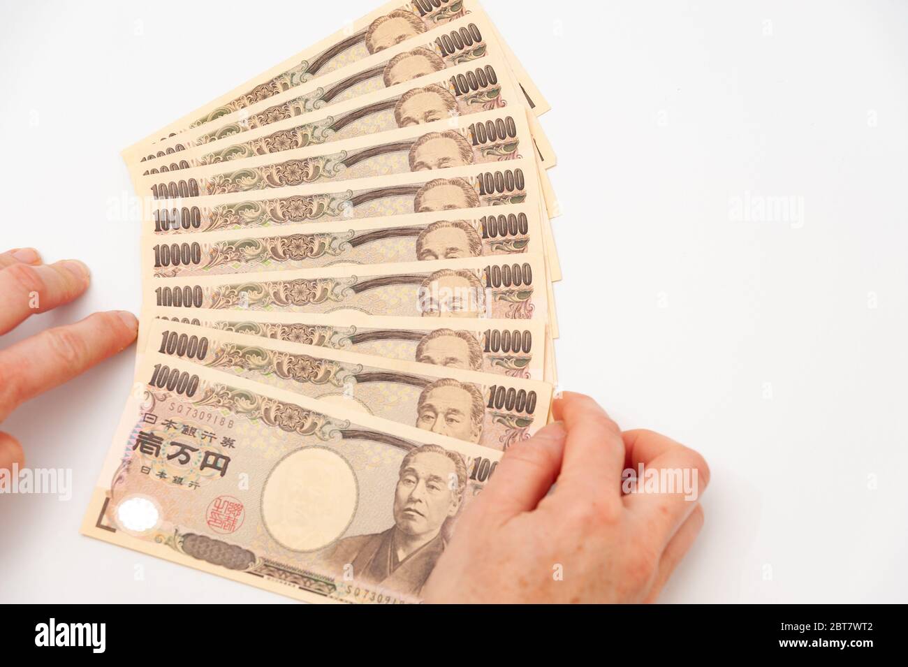 Mains tenant 100,000 yens. Isolé sur fond blanc. Copier l'espace. Tir horizontal. Banque D'Images