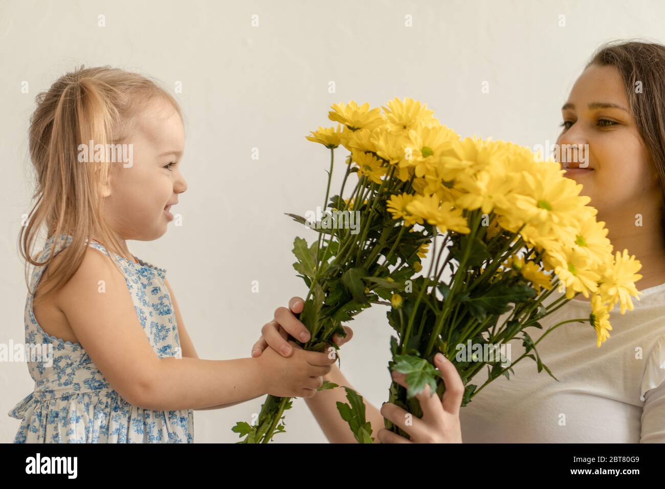 Maternite Fete Des Meres Anniversaire Enfance Concept De Famille Petite Fille En Gros Plan Robe Bleue Coloree Feliciter Et Donner A La Jeune Mere Brillant Photo Stock Alamy