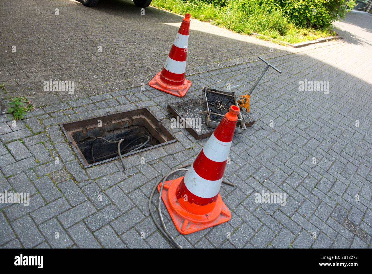 Travaux de réparation sur le dépannage ou les travaux d'entretien communaux. Ouvrez la trappe du fer avec le câble qui va à l'intérieur Banque D'Images