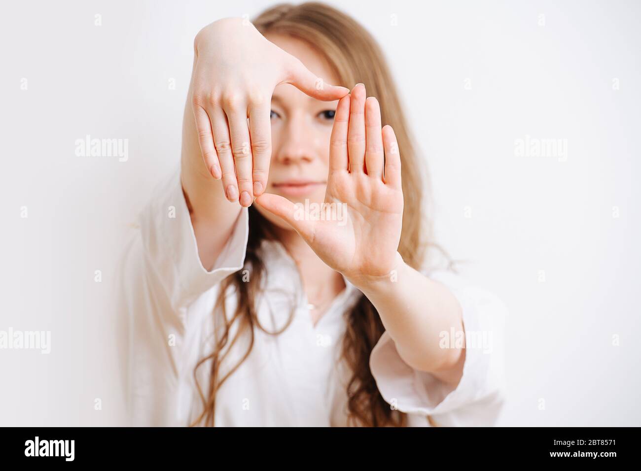 Fille qui étire ses bras vers l'avant, elle fait le cadrage avec ses mains Banque D'Images