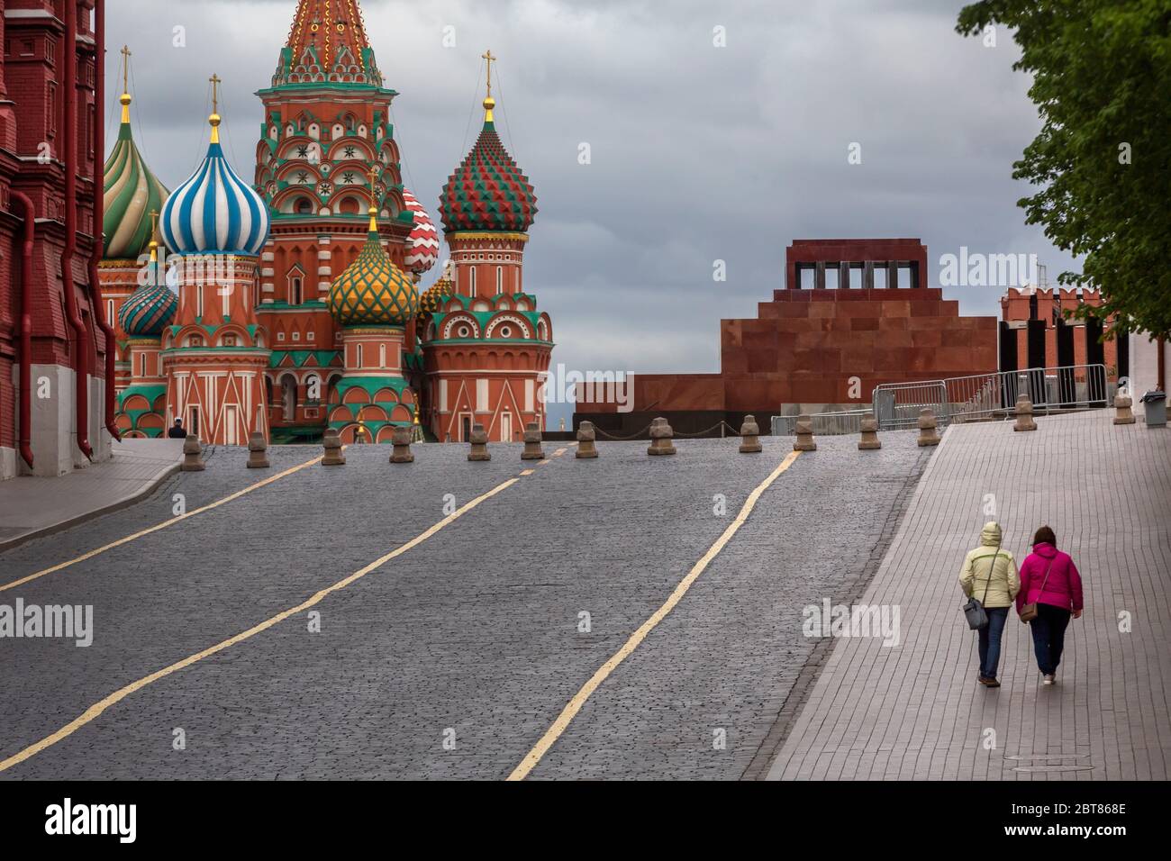 Les femmes marchent le long d'une place rouge vide dans le centre de Moscou, Russie Banque D'Images