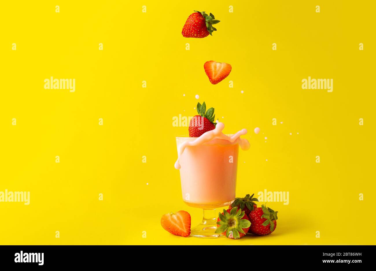 barbotage jus de fraise smoothies et fraises sur fond jaune comme des boissons diététiques de detox Banque D'Images barbotage jus de fraise smoothies et fraises sur fond jaune comme des boissons diététiques de detox Banque D'Images