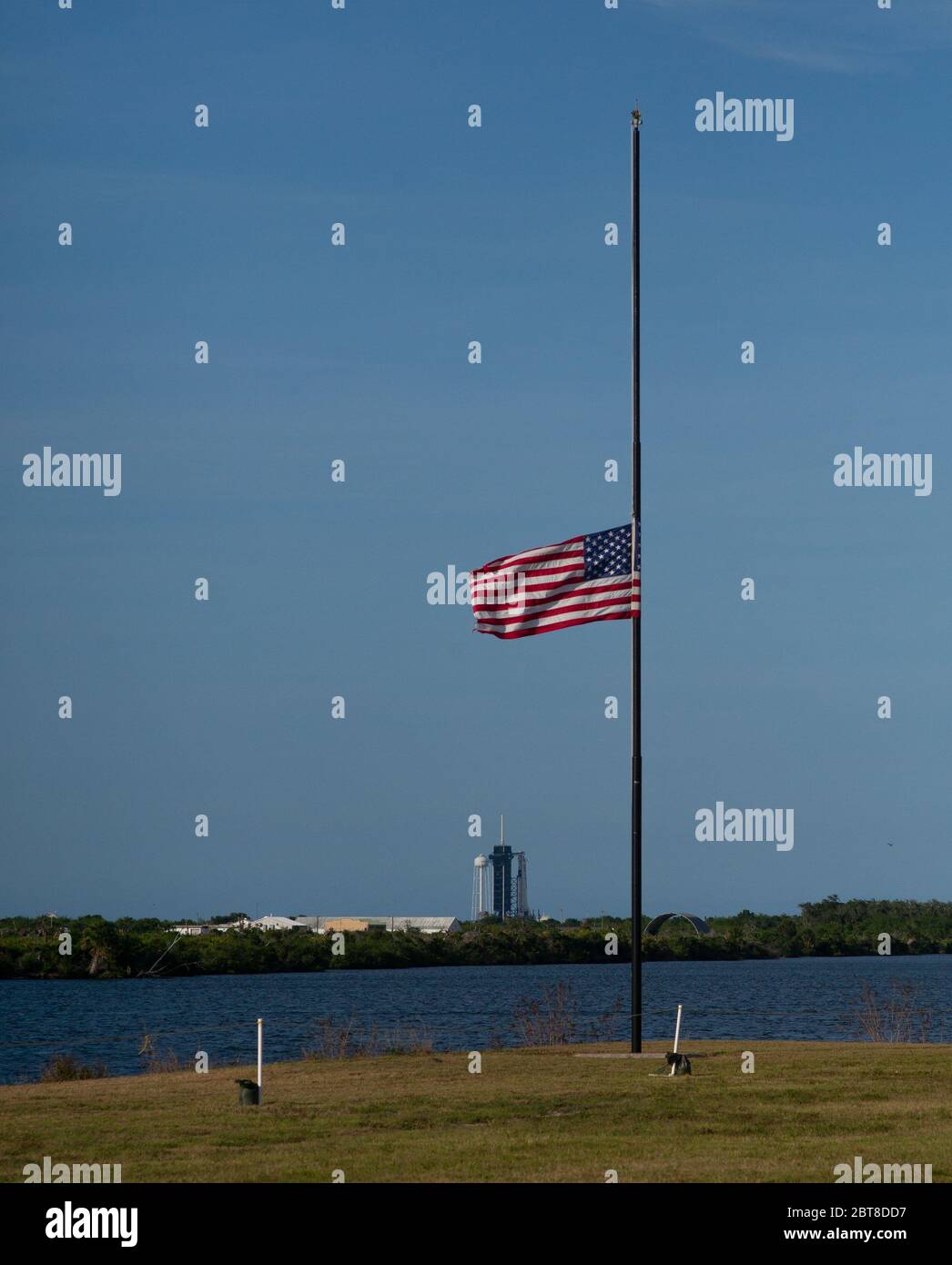 Cape Canaveral, Floride, États-Unis. 22 mai 2020. Le drapeau américain vole à la moitié du personnel à côté de l'horloge du compte à rebours au site de presse du Kennedy Space Center de la NASA, le 22 mai 2020, en Floride. Le président Donald Trump a ordonné jeudi que les drapeaux soient abaissés à moitié d'employés jusqu'au coucher du soleil le 24 mai, « comme marque de respect solennel pour les victimes de la pandémie du coronavirus ». La mission SpaceX Demo-2 de la NASA est le premier lancement avec les astronautes du vaisseau spatial SpaceX Crew Dragon et de la fusée Falcon 9 vers la Station spatiale internationale dans le cadre du programme d'équipage commercial de l'agence. Crédit : UPI/Alay Live News Banque D'Images