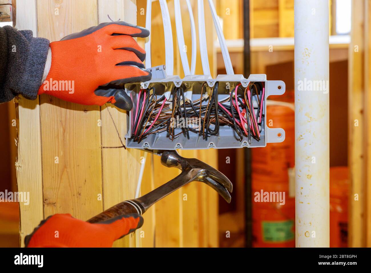 Le travailleur met sur l'installation des prises électriques dans une nouvelle maison Banque D'Images