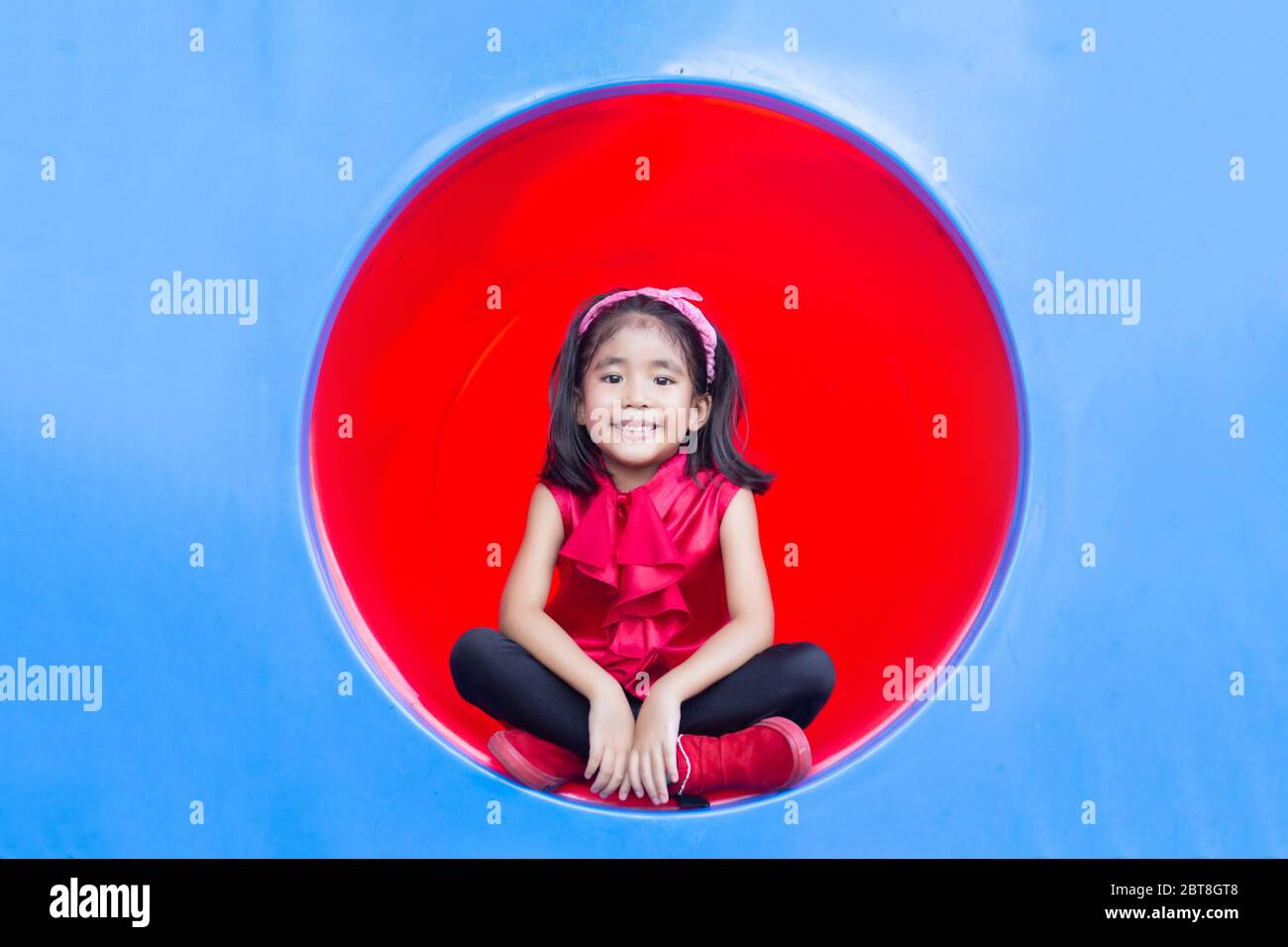 souriez les enfants asiatiques sur le cercle de parc de jeux en plastique Banque D'Images