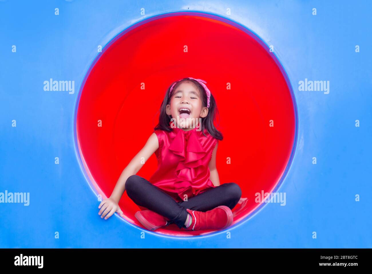 souriez les enfants asiatiques sur le cercle de parc de jeux en plastique Banque D'Images