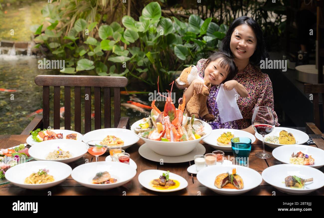 Portrait de maman et fille au jardin du restaurant de homard crevettes steak bœuf pâtes d'agneau spaghetti risotto riz sushi sashimi et vin à l'aide de FO Banque D'Images