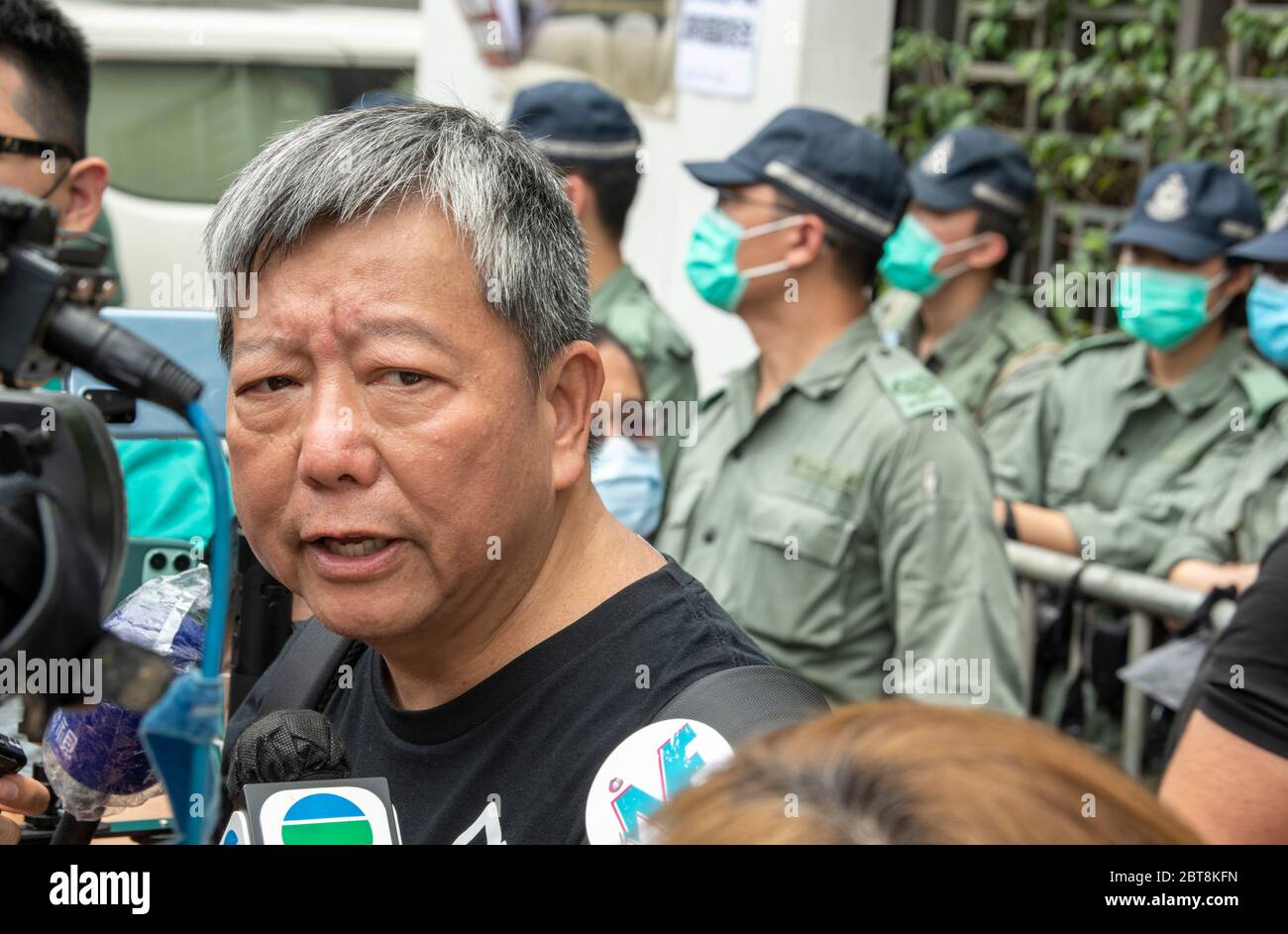 HONG KONG, HONG KONG SAR, CHINE : 24 MAI 2020. Avec cette année, le 4 juin événement interdit, les gens participent à une course de 10 km pour commémorer le 31 anniversaire du mouvement démocratique en Chine de 1989 qui s'est terminé avec l'incident de la place Tienanmen. La course prend des sites importants pour la lutte pour la démocratie à Hong Kong.LEE CHEUK-YAN (c), ancien législateur et l'un des "Democracy 15" arrêtés, parle à l'extérieur du Bureau de liaison du Gouvernement populaire central de Hong Kong RAS, Sai Yin Pun. La police fait sentir leur présence. Alamy Live News/Jayne Russell Banque D'Images
