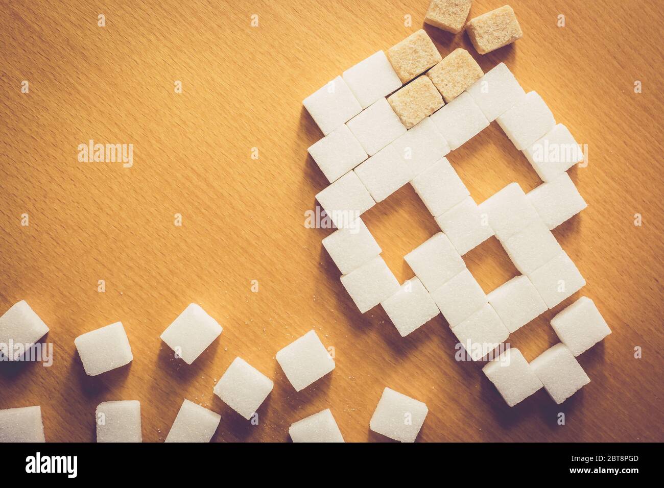 Crâne de sucre sur fond de bois, sucre blanc et brun, sucre dangereux, concept alimentaire Banque D'Images