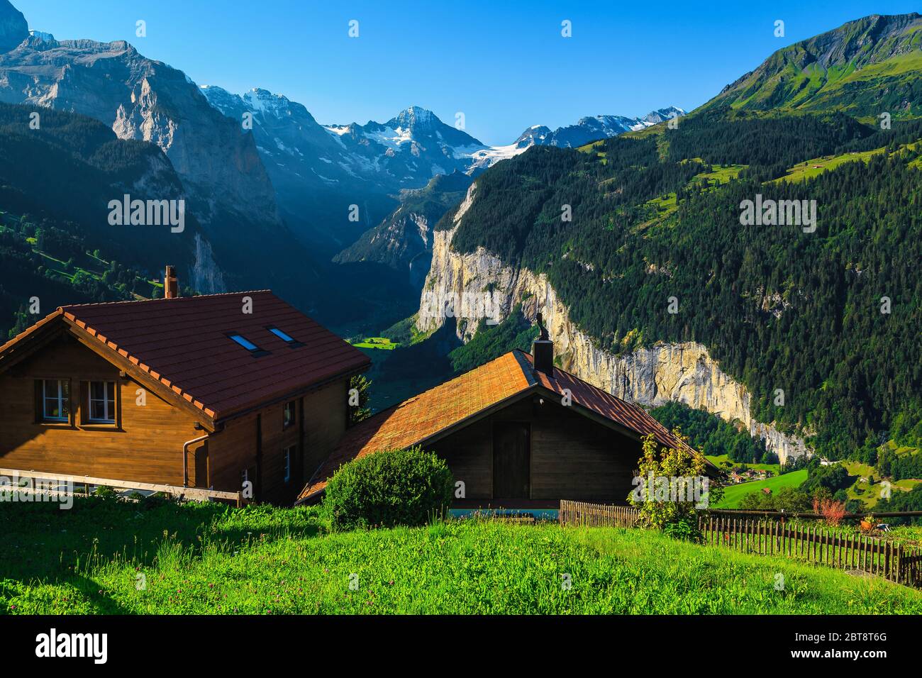 Chalets en bois confortables avec vue imprenable depuis la station de montagne de Wengen. Vallée de Lauterbrunnen et montagnes avec glaciers en arrière-plan, Oberlan bernois Banque D'Images