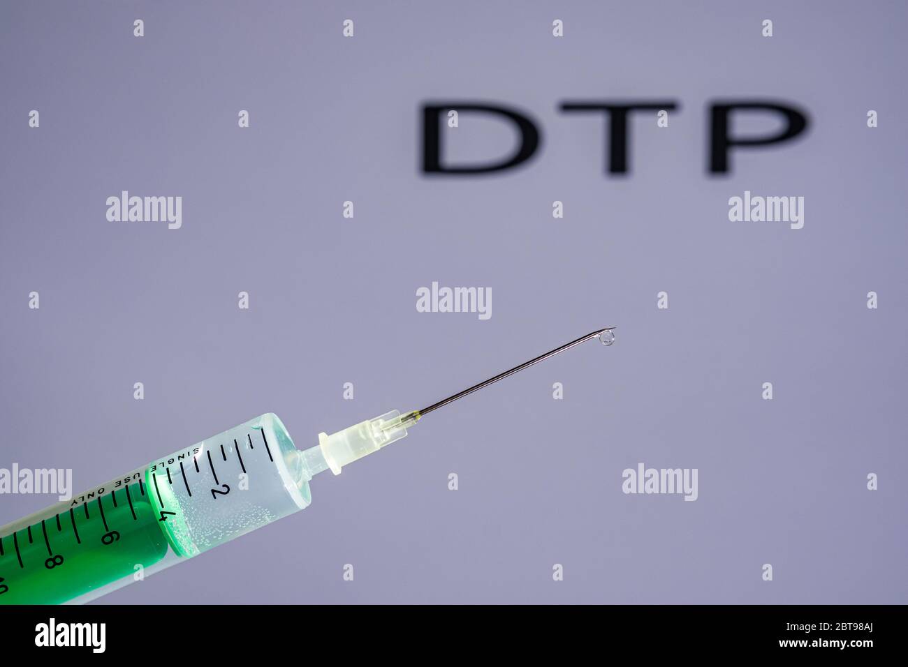 Cette photo illustre une seringue jetable avec aiguille hypodermique, DTP écrit sur un tableau gris derrière Banque D'Images
