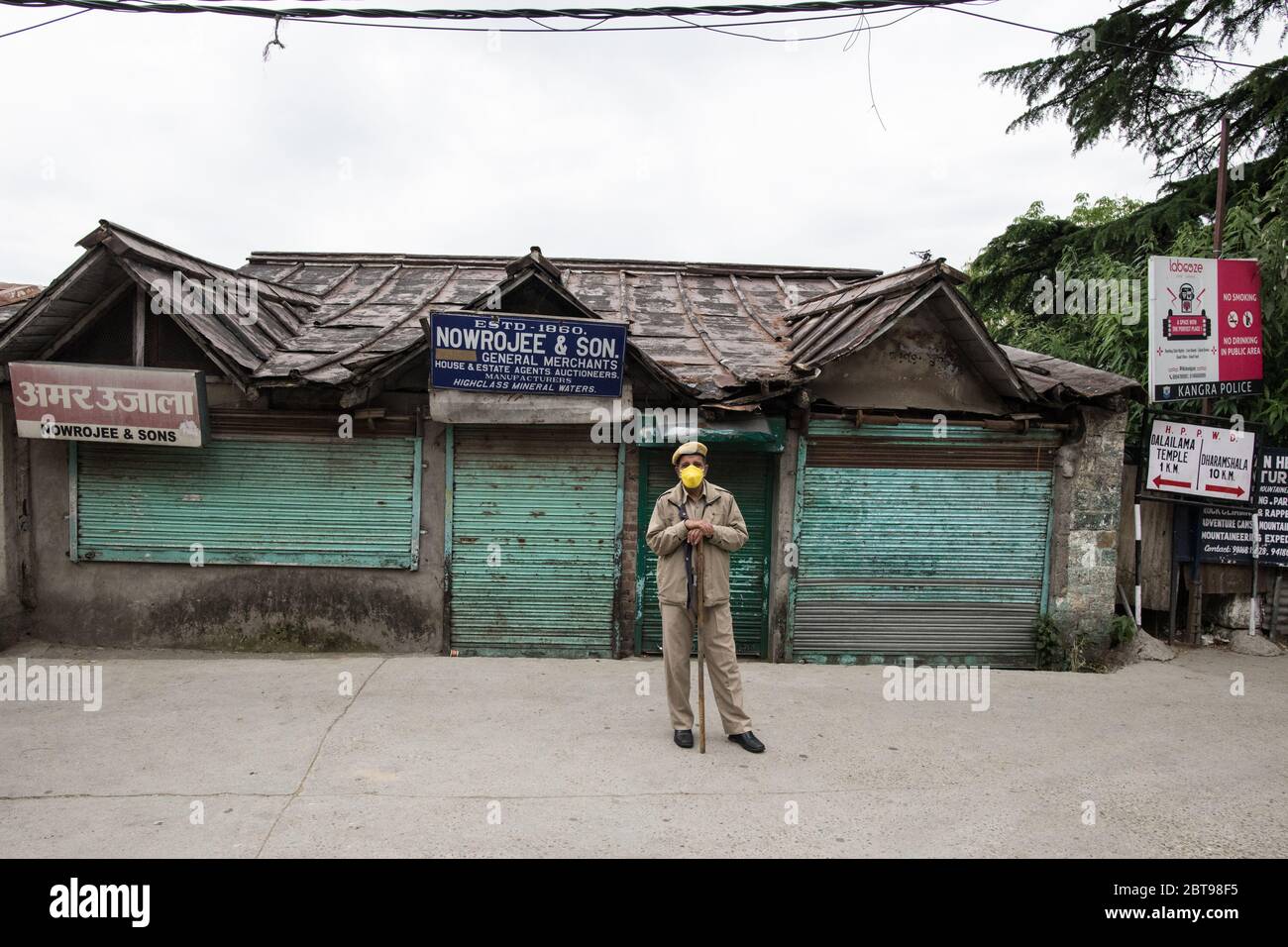 Agent de police portant un masque de protection et faisant respecter la distanciation sociale pour prévenir la propagation du coronavirus COVID 19. Dharamshala, Inde. Banque D'Images