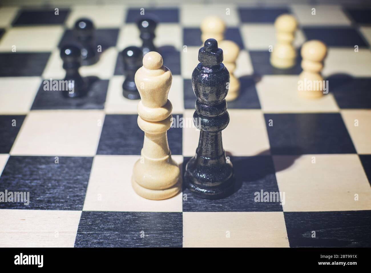Le chessboard avec le roi noir et la reine blanche devant dans le concept de l'accord et des pions en arrière-plan Banque D'Images