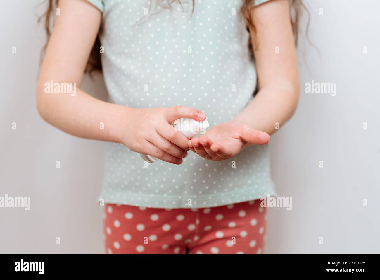 L'enfant utilise un gel antiseptique antibactérien pour désinfecter les mains des bactéries. Prévention et contrôle des infections à coronavirus COVID-19. Banque D'Images