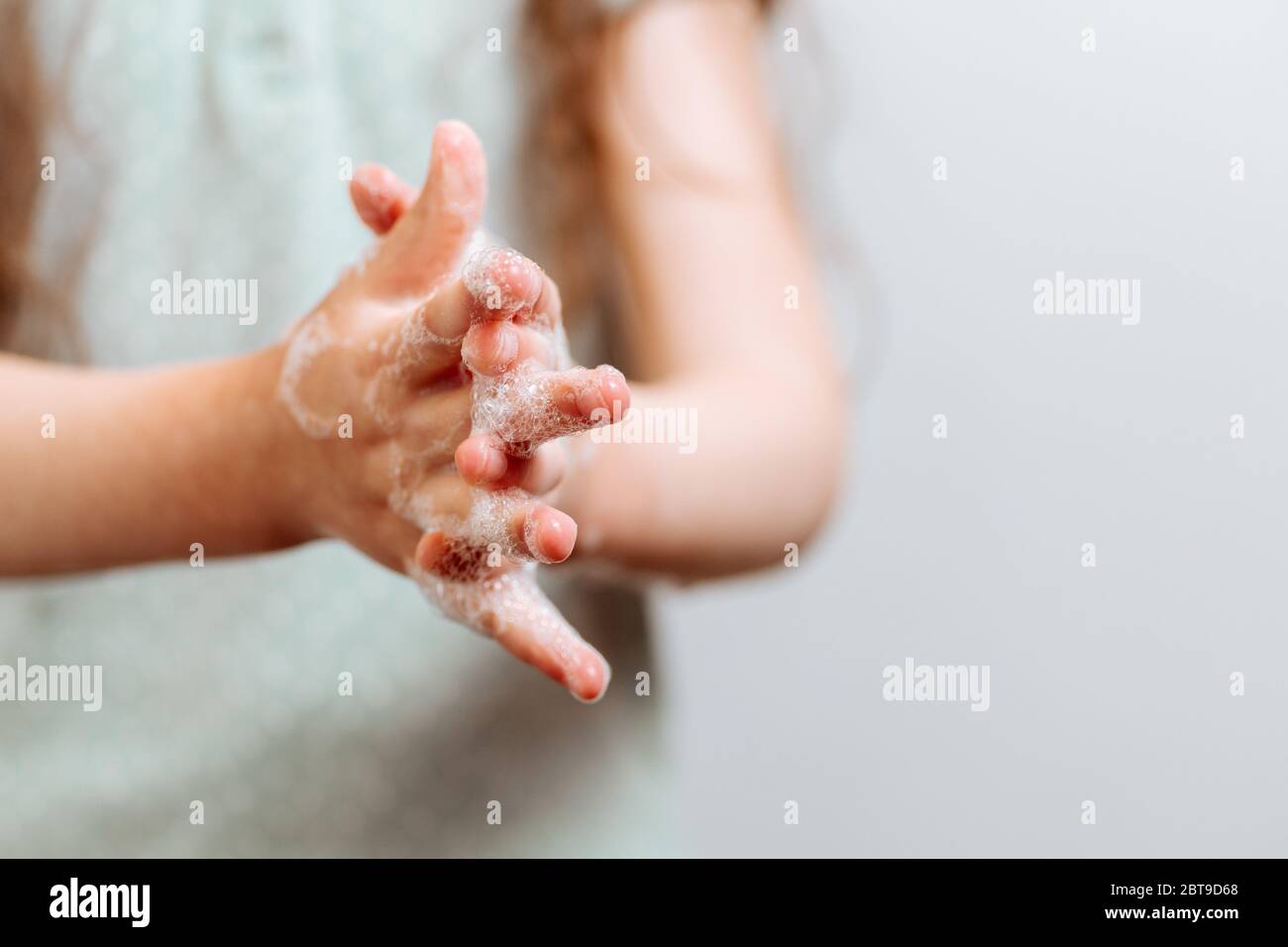 Mains d'enfants dans de la mousse savonneuse. Concept d'hygiène prévenir la propagation des germes et des bactéries et éviter les infections du virus corona Banque D'Images