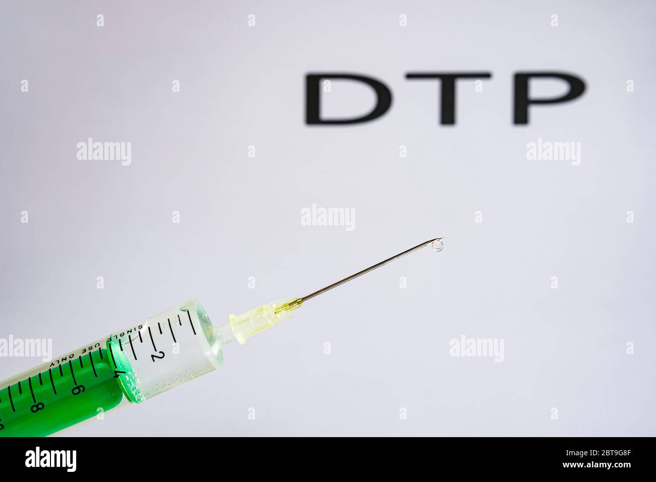 Cette photo montre une seringue jetable avec aiguille hypodermique, DTP écrit sur un tableau blanc derrière Banque D'Images