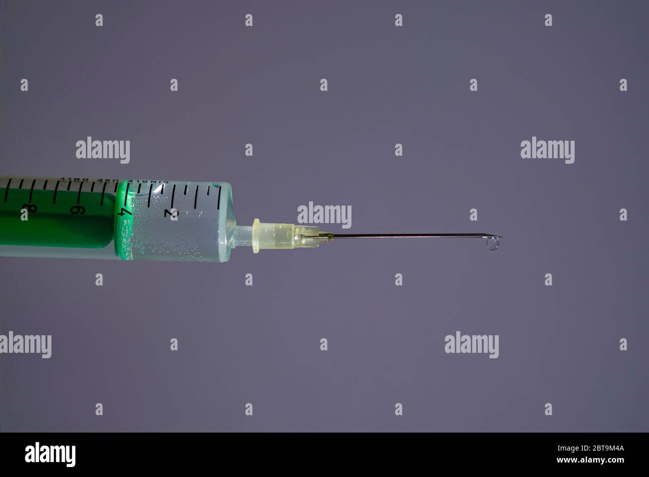 Cette photo montre une seringue jetable avec aiguille hypodermique, un tableau gris derrière Banque D'Images