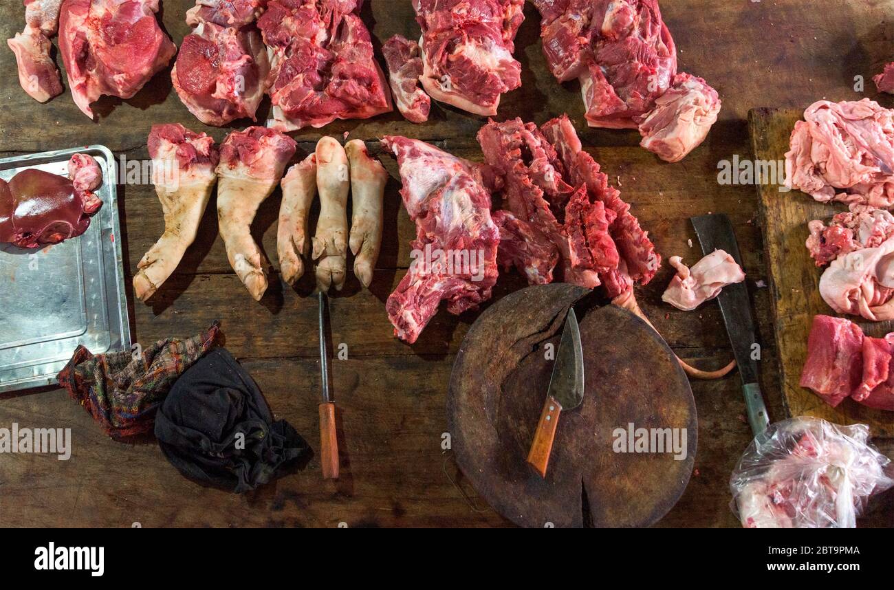 assortiment de viandes crues et couteau sur la table de travail en bois foncé du boucher. Vue de dessus. Banque D'Images