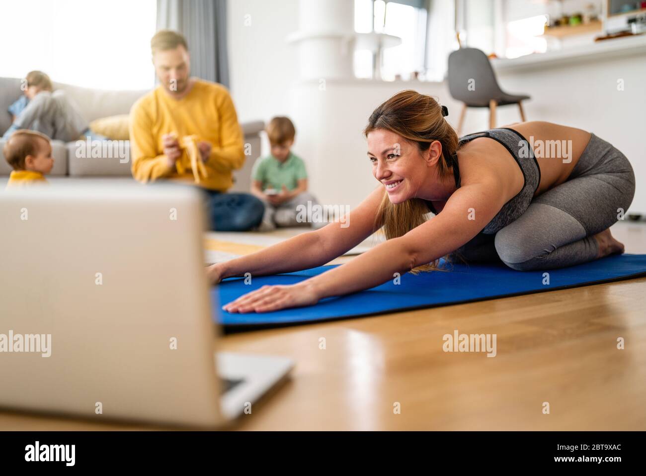 La jeune femme fait de l'exercice de yoga à la maison. Forme physique, entraînement, vie saine et concept de régime. Banque D'Images