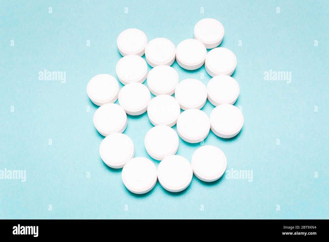 Pilules rondes et blanches sur fond bleu. Concept de traitement de la maladie, soins de santé Banque D'Images