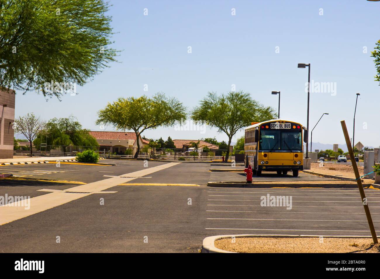Bus scolaire dans le stationnement vide de l'école secondaire en raison de la quarantaine du coronavirus Banque D'Images
