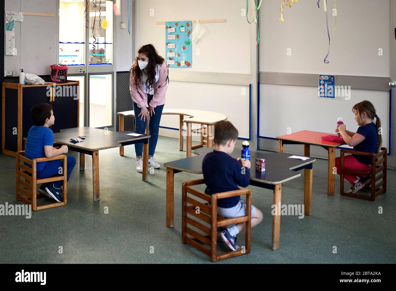 Borgossia, Italie - 12 mai 2020 : un éducateur parle avec des enfants de maternelle dans une école maternelle, dans le cadre d'un test pilote pour voir comment les écoles peuvent rouvrir après le confinement du coronavirus COVID-19 dans la région du Piémont, proposé par le maire de Borgossia (Vercelli) Paolo Tiramani. Crédit: Nicolò Campo/Alay Live News Banque D'Images