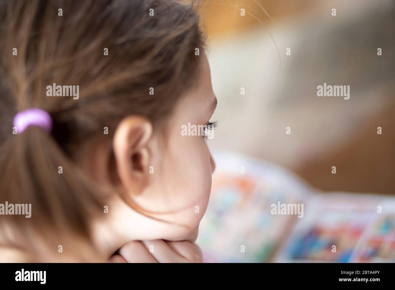 Une jeune fille qui s'est allongée sur le sol et qui lit un magazine pour adolescents Banque D'Images