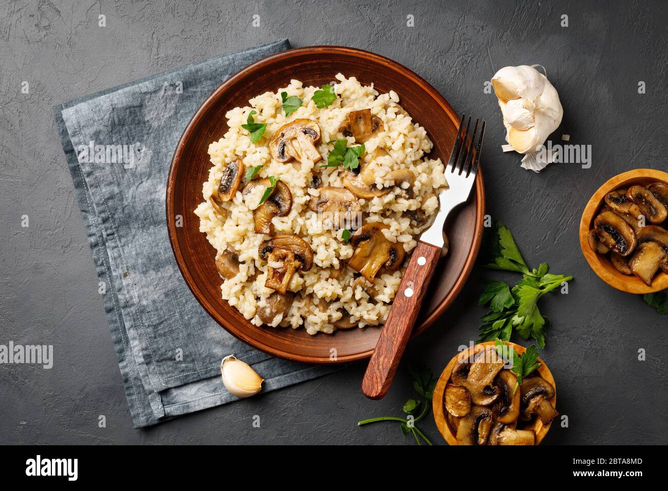 Un plat de cuisine italienne - risotto au riz et aux champignons dans une  assiette brune sur fond d'ardoise noire. Vue ci-dessus Photo Stock - Alamy