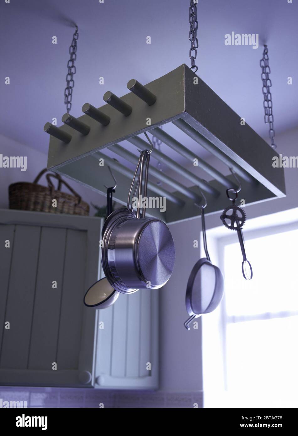 Les casseroles en acier inoxydable sur rack de plafond au-dessus de table  en cuisine 80 Photo Stock - Alamy