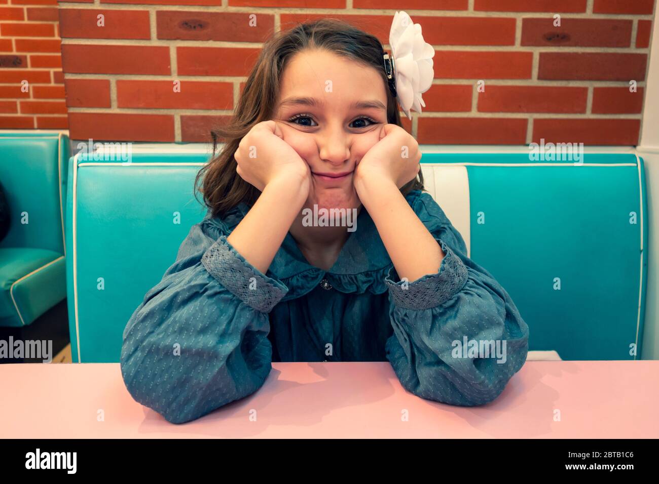 Jeune fille assise dans un restaurant de hamburgers (HD Diner à Paris, France) Banque D'Images