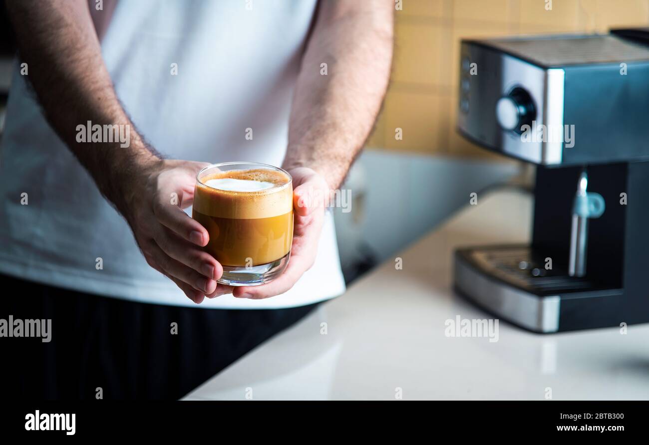 Homme tenant un cappuccino maison dans une tasse en verre. Concept de style  de vie intérieur de barista à domicile Photo Stock - Alamy