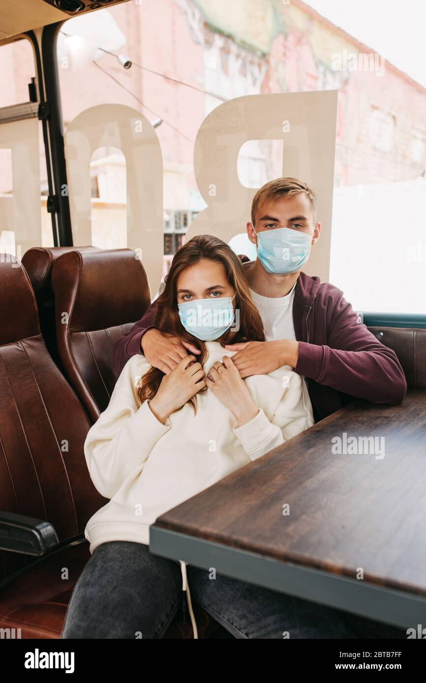 Couple dans le bus, voyageant ensemble, portant un masque hygiénique pour prévenir le virus Banque D'Images
