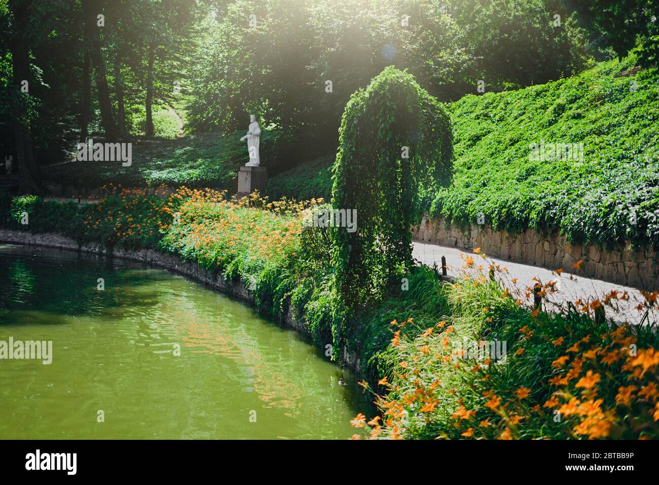 Parc Sofia, Uman. Belles fleurs jaunes au bord de la rivière dans le parc. Parc vert avec lac et statues blanches. Rivière dans le parc, fleurs d'orange et a s Banque D'Images