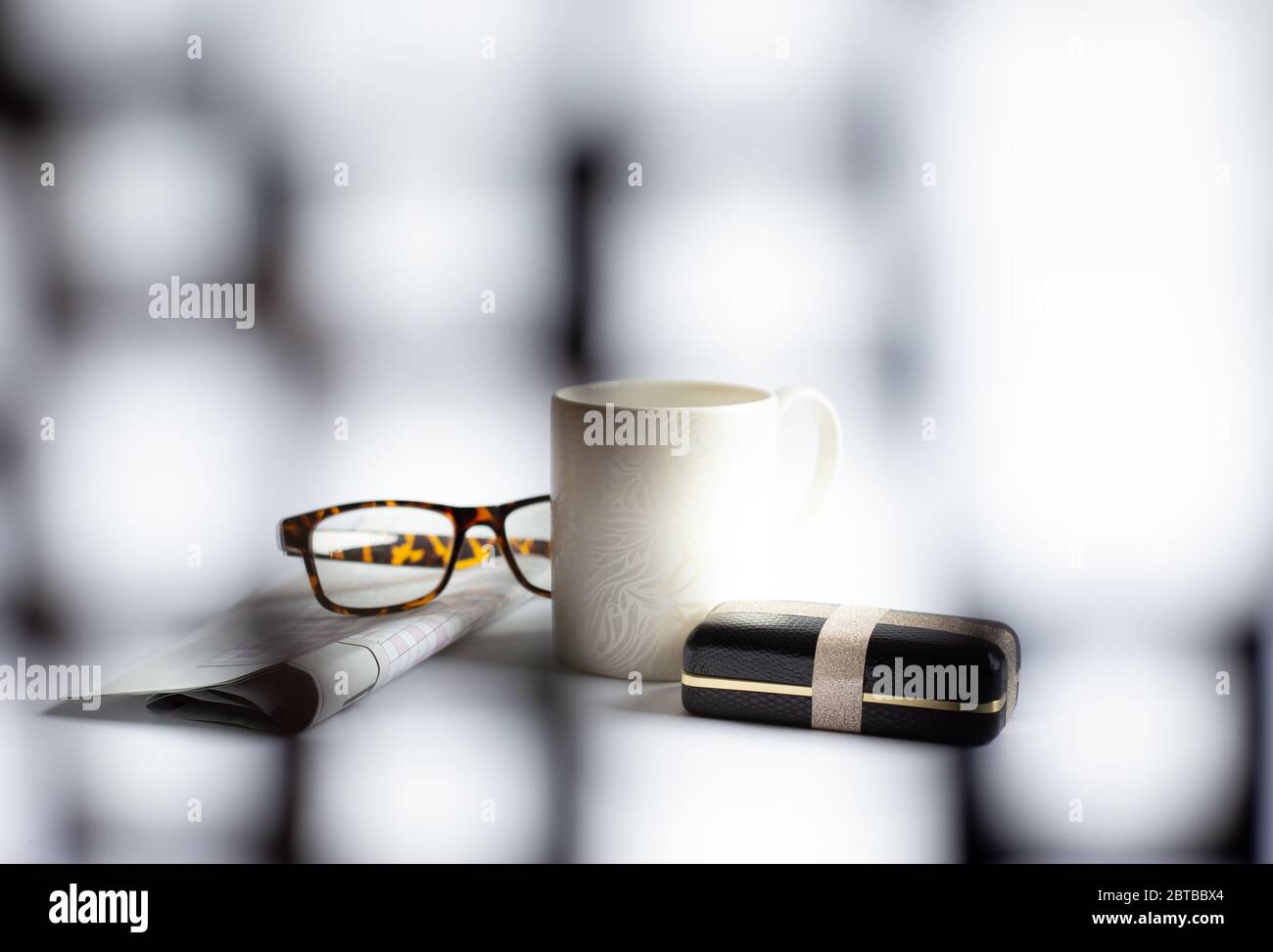 Tasse de café du matin, lunettes, boîte cadeau emballée, journal avec mot-croix sur fond clair, mise au point douce. Concept de la fête des Pères heureux Banque D'Images