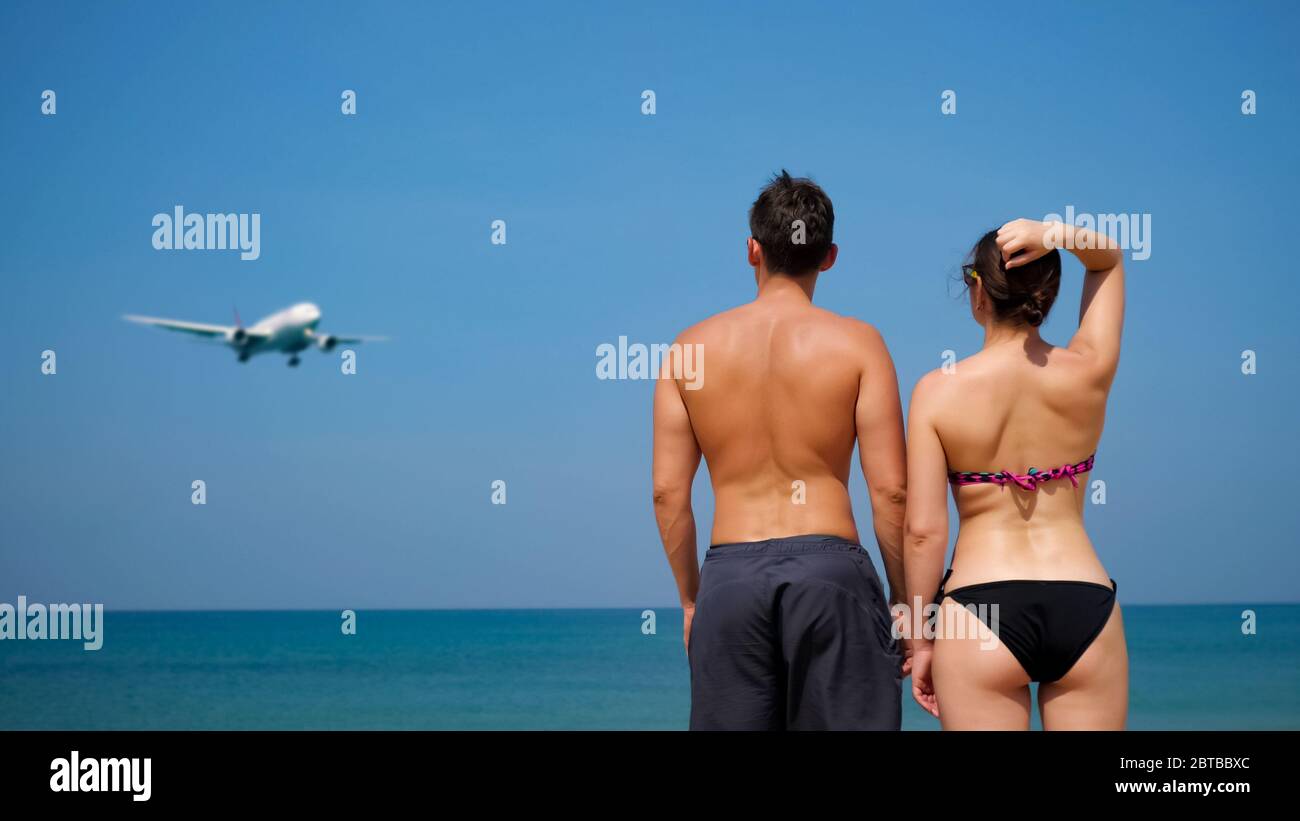 petite amie en bikini et petit ami se tenir près de l'immense océan calme  et regarder s'approcher de l'avion sous ciel bleu vue arrière Photo Stock -  Alamy