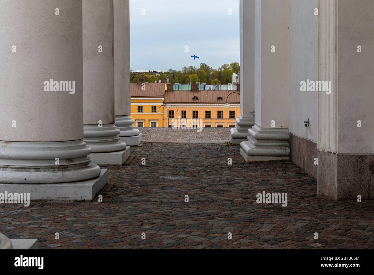 Colonnes architecturales, toits d'Helsinki et drapeau finlandais volant haut sans personne en scène. Banque D'Images