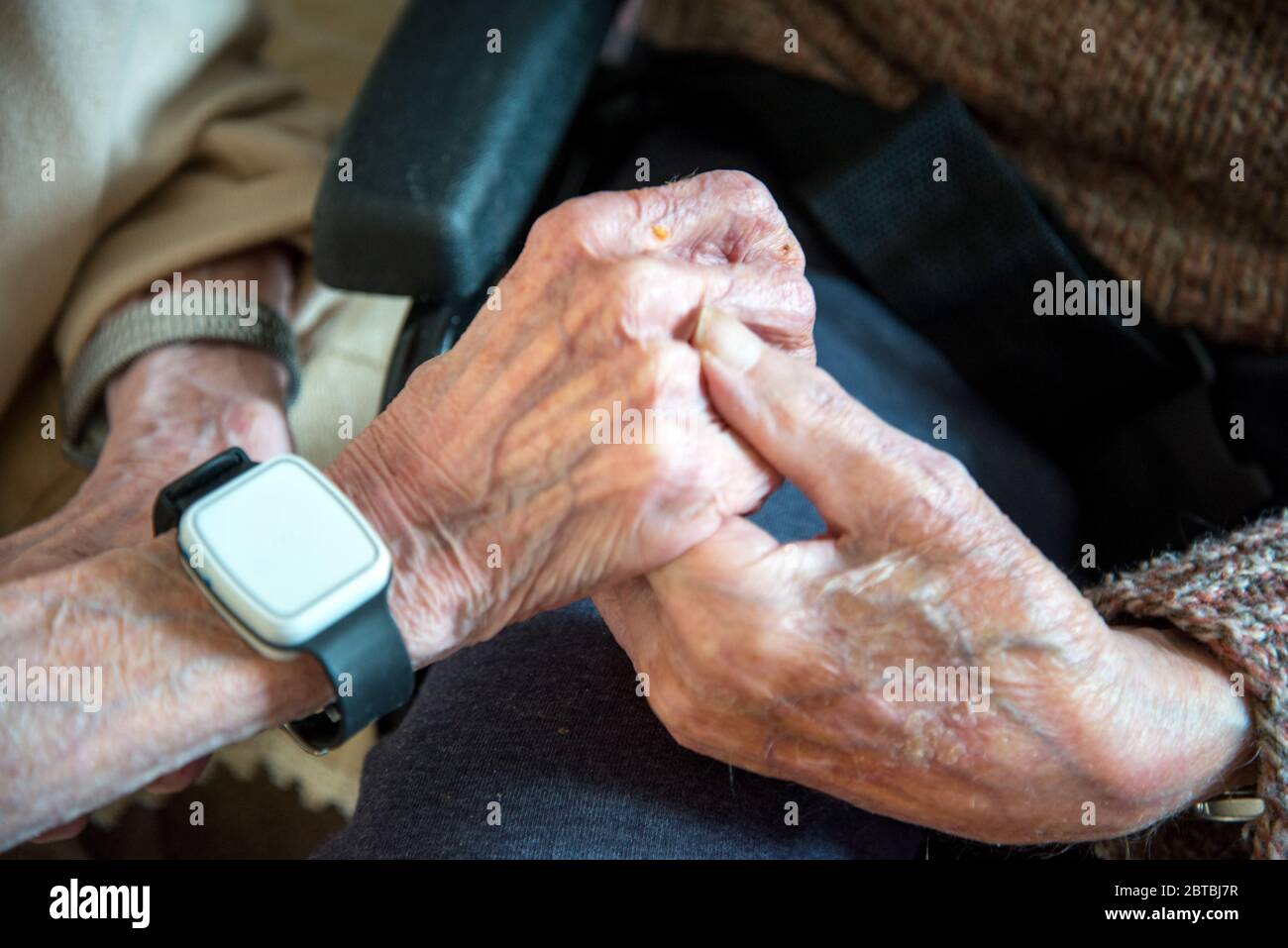 Leurs vieilles mains se rassemblent, toujours amoureux dans leurs années 90, ensemble, vivant et dormant dans le salon en bas en raison de leur mauvaise santé Banque D'Images