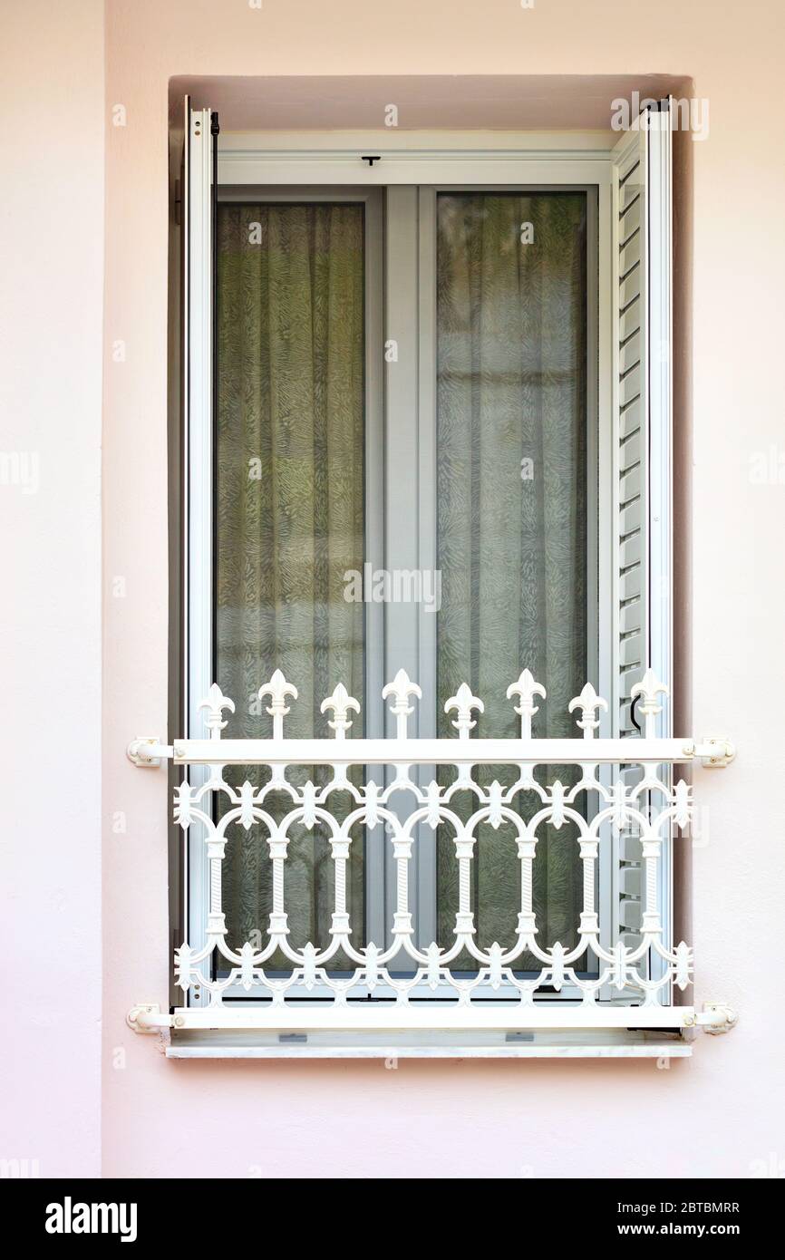 Portes-balcons modernes en métal et plastique avec volets en treillis et rideau dense de la pénétration de la lumière du soleil et une grille décorative en métal. Banque D'Images