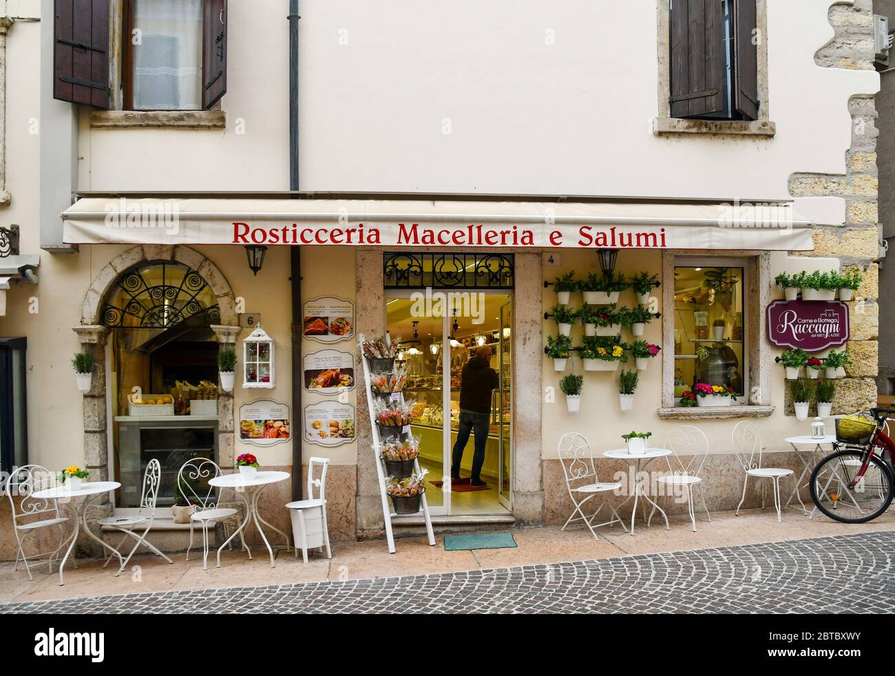 Extérieur et entrée d'une rôtisserie et épicerie fine dans le centre historique de la vieille ville avec des tables sur le trottoir, Lazise, Vérone, Italie Banque D'Images