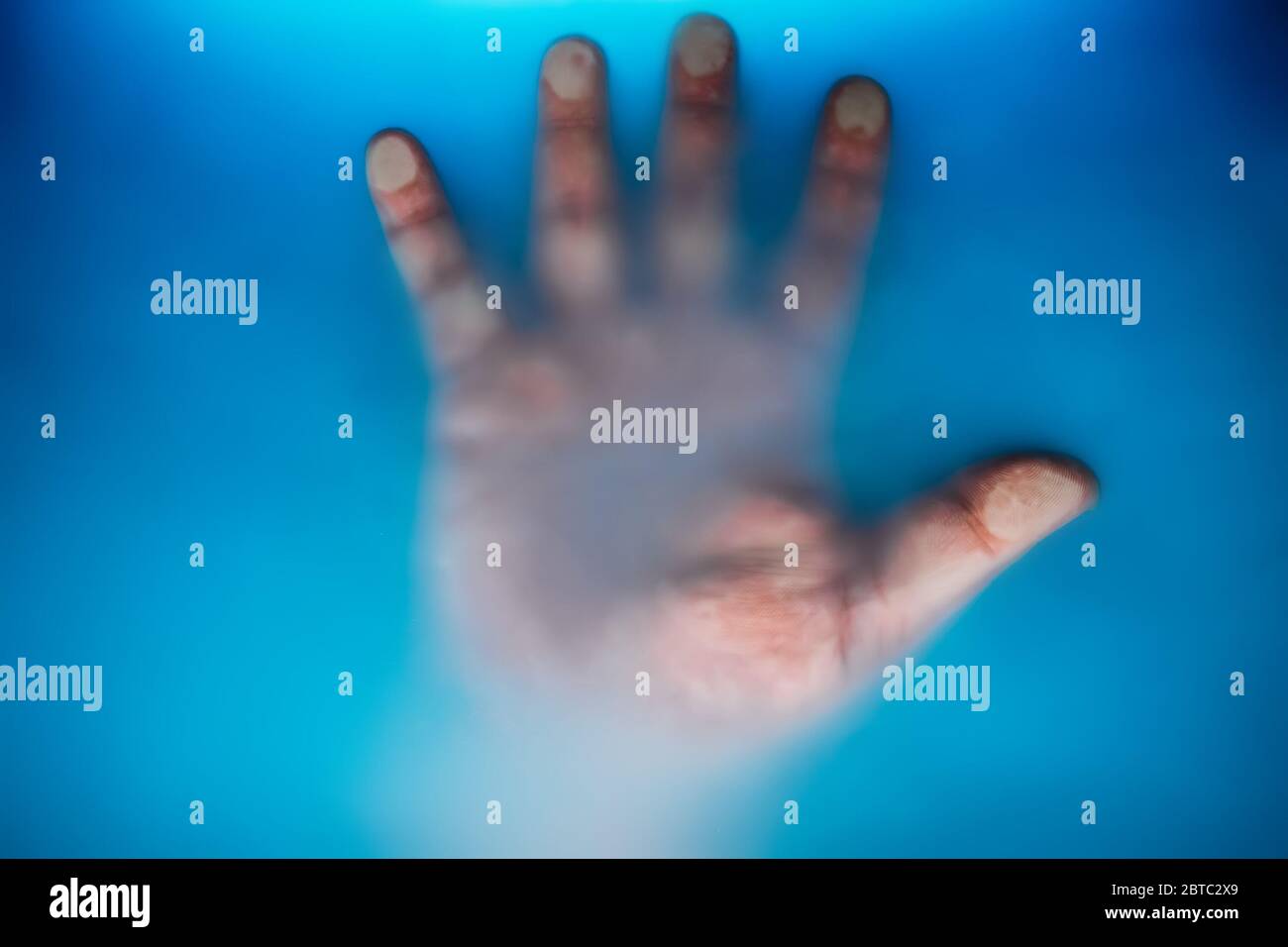 Verre pressé de paume mâle dans l'eau bleue boueuse comme symbole de danger sous-marin, d'échec ou de besoin d'aide. Également horreur effrayante fantôme pour halloween concept abstrait. Banque D'Images