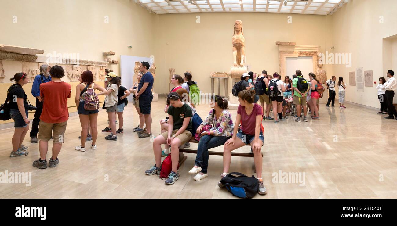 Touristes et groupes de visite au Musée archéologique de Delphes à Delphes, Grèce. Le Sphinx de Naxos est en arrière-plan. Banque D'Images