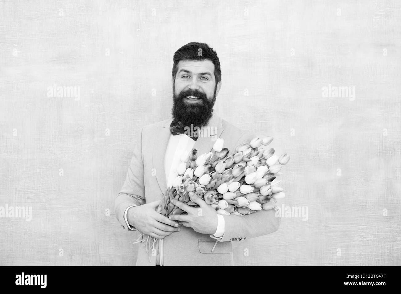 Idées à célébrer sans briser la banque. Ambiance printanière. Date d'amour. Bouquet cadeau. Hipster homme barbu avec bouquet de fleurs. Bouquet de fleurs pour femme. Homme barbu avec tulipes. Boutique de fleurs. Banque D'Images