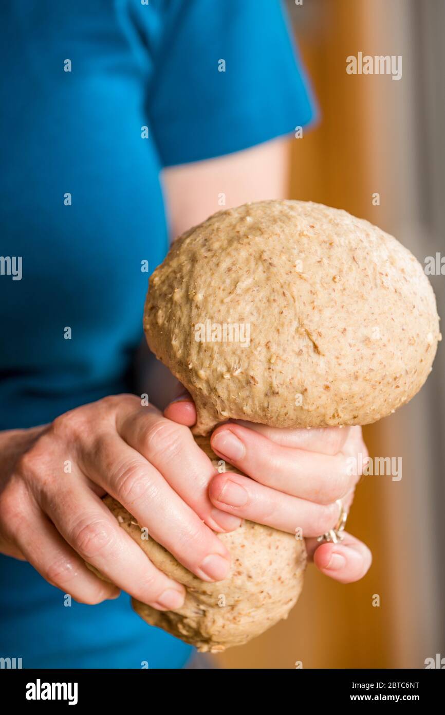 Femme qui se coince de la pâte multi-grains pour obtenir la bonne quantité pour faire une croûte de pizza Banque D'Images