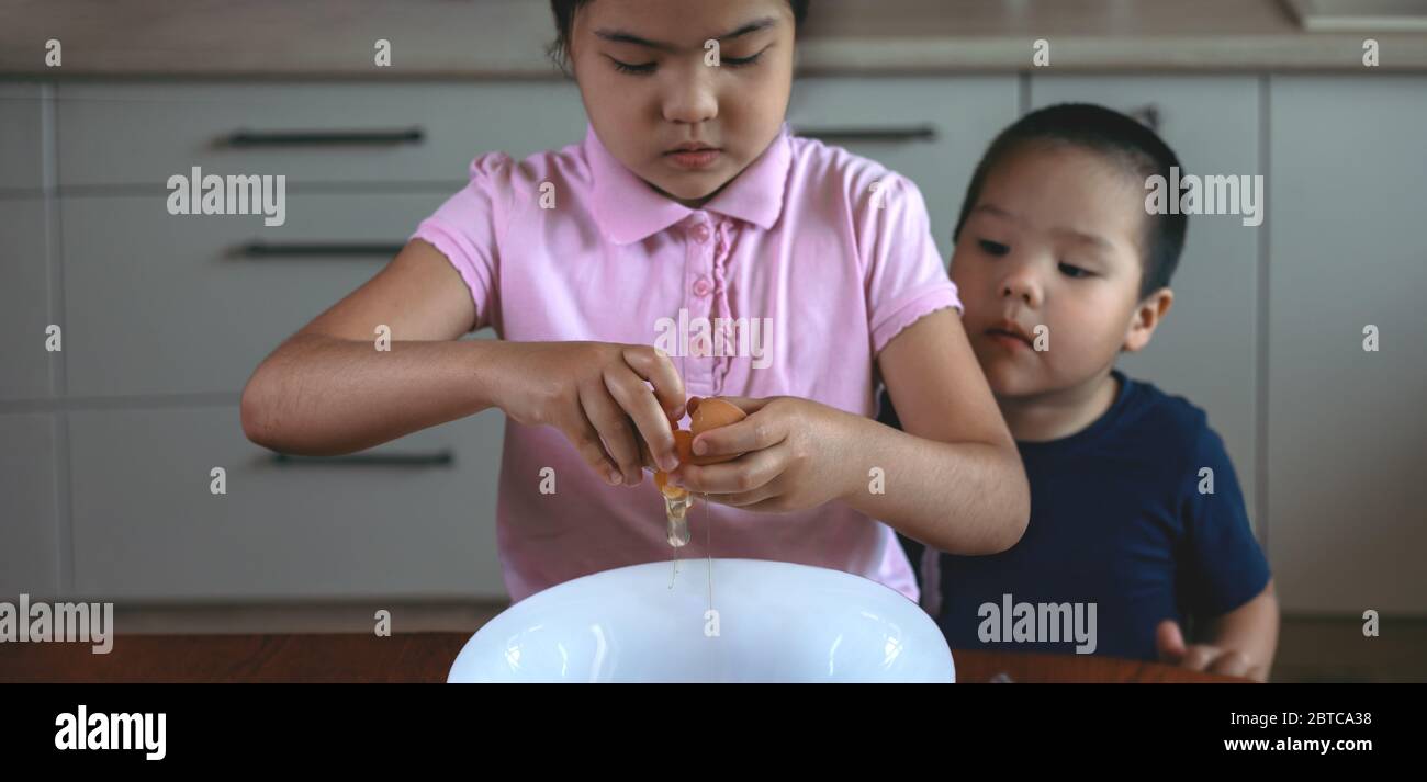 Deux enfants préparent la nourriture à la maison dans la cuisine Banque D'Images