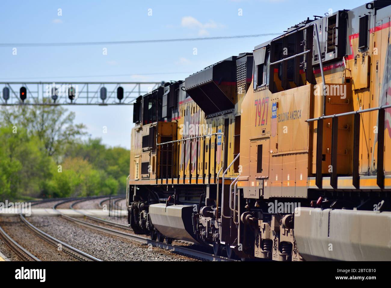 Winfield, Illinois, États-Unis. Les locomotives dirigent un train de marchandises Union Pacific au-dessus d'un passage à niveau et vers une tour de signalisation à Winfield, Illinois. Banque D'Images