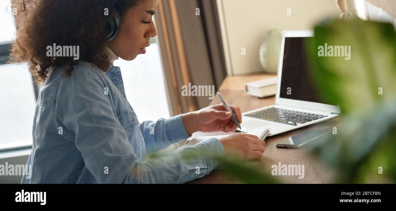 Fille africaine étudiant porter des écouteurs distance eLearning en ligne à la maison, bannière. Banque D'Images
