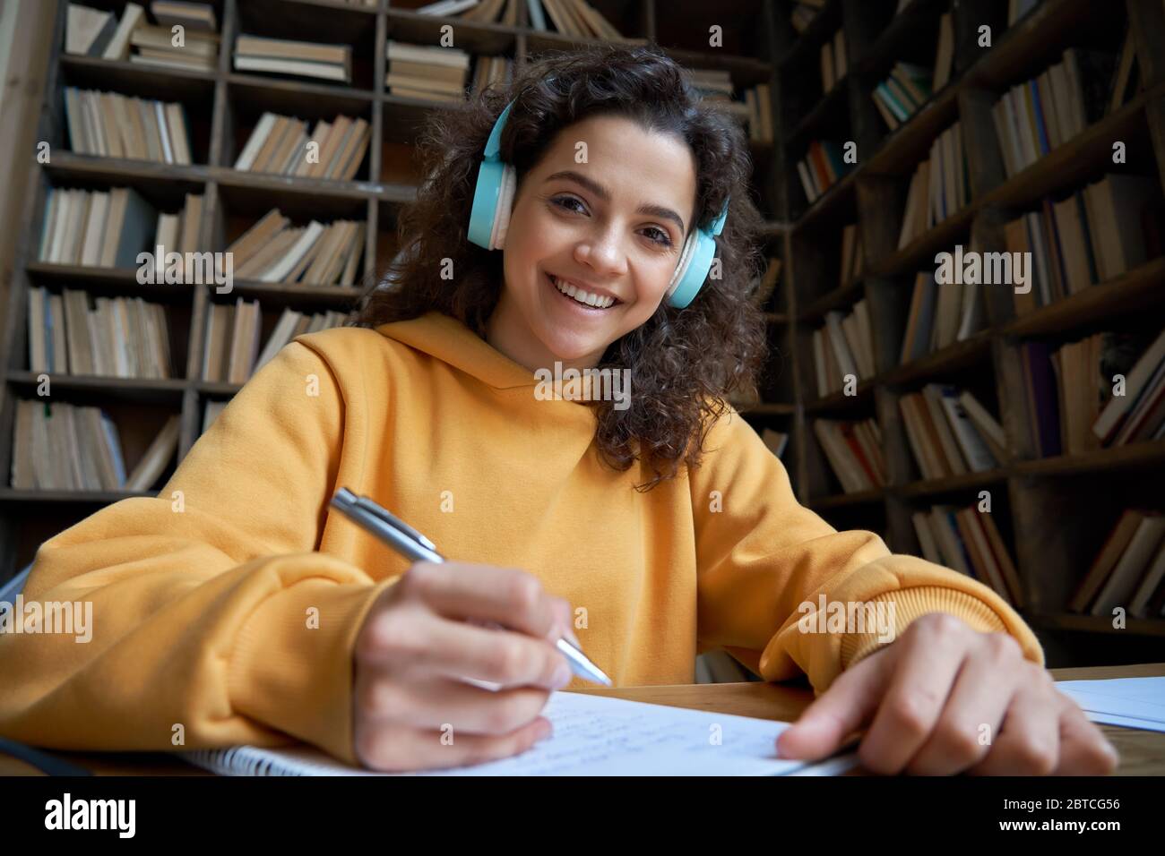 Souriant hispanique jeune fille étudiant regardant à la webcam à distance apprentissage. Banque D'Images