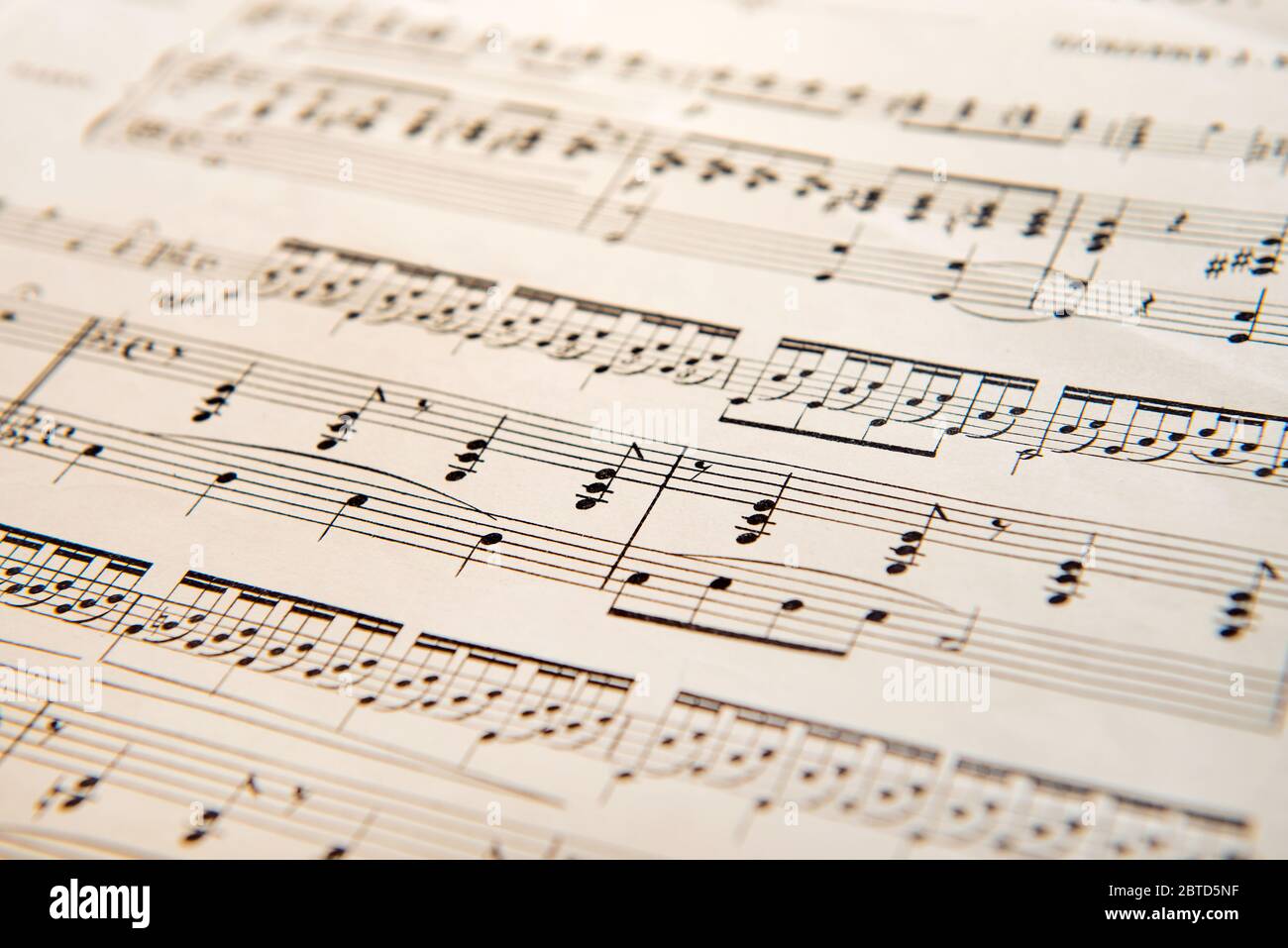 Gros plan sur un score musical imprimé avec un focus sur les notes au centre et un espace de copie sur le flou environnant Banque D'Images