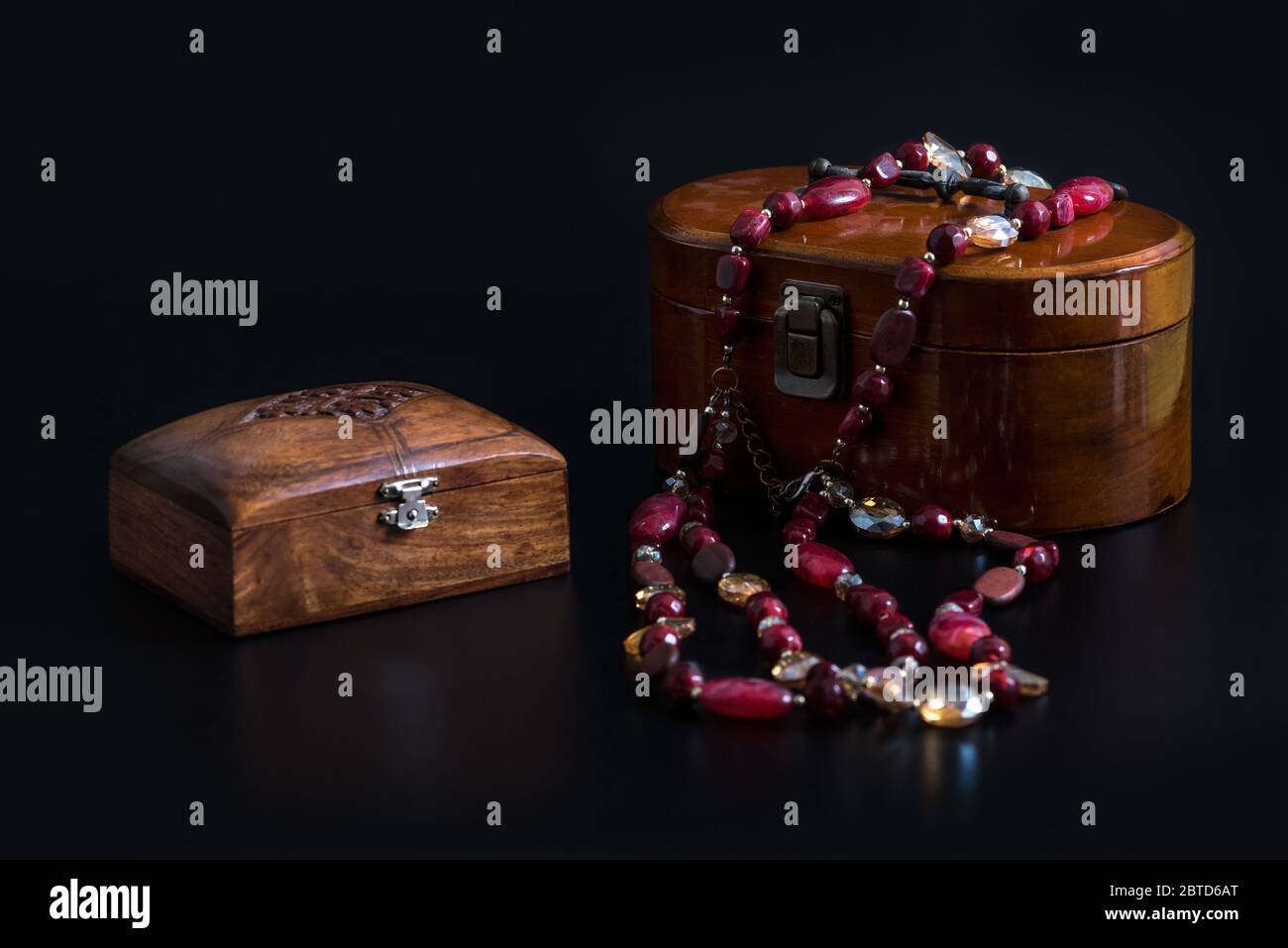 Deux anciens bijoux en bois et un collier de perles de verre isolé sur fond  noir. Boîtes en bois pour différentes décorations ou de petites carabines  Photo Stock - Alamy