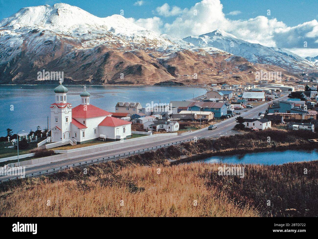 Le rouge et le vert d'un toit de style russe-orthodoxe eglise apporte une touche de couleur à l'hiver dans ce paysage montagneux scène Unalaska. Banque D'Images